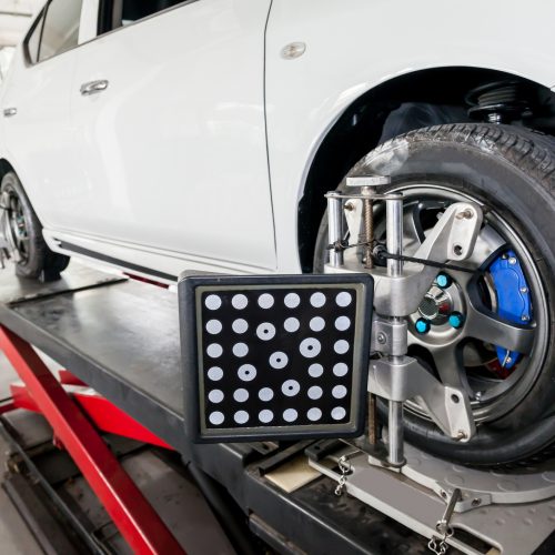 Suspension adjustment and Automobile wheel alignment work being installed with computerized alignment machine clamp